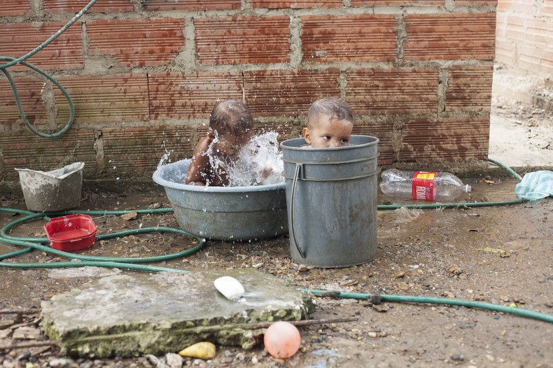Neymar and Sebastian taking a bath in Barrio Membrillar, a community of cinder block and wood houses built by people who have been internally displaced. The boys&#039; grandmother, Gavelys, was displaced from Atanquez, Valledupar, in 2006.